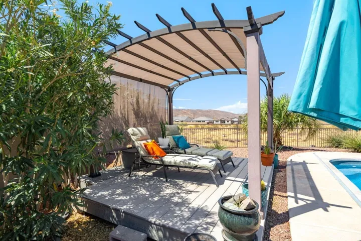 Curved pergola with a retractable fabric canopy over a composite deck