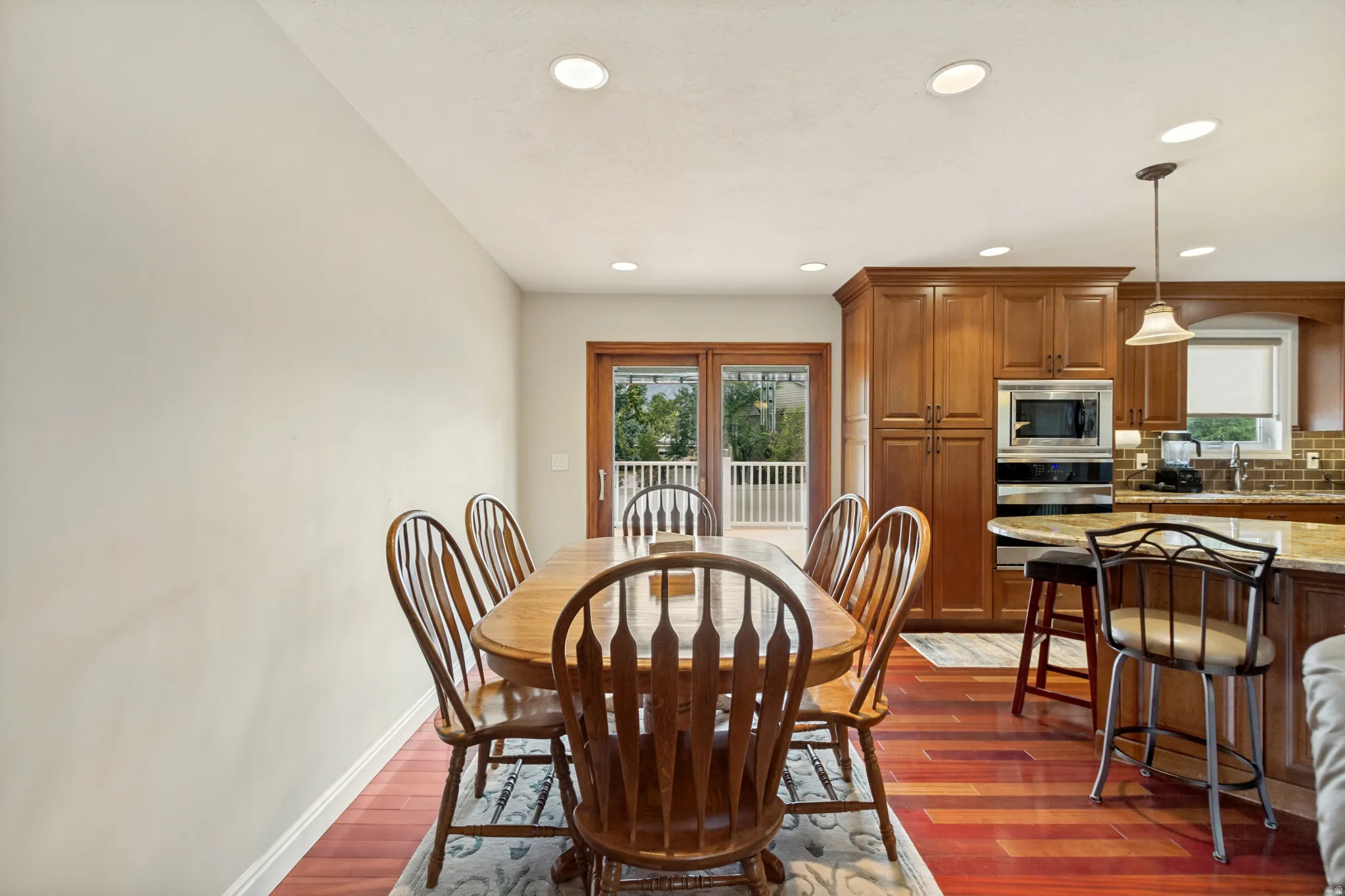 Open-concept dining area featuring wood-finish flooring, recessed lighting, and a neutral wall color