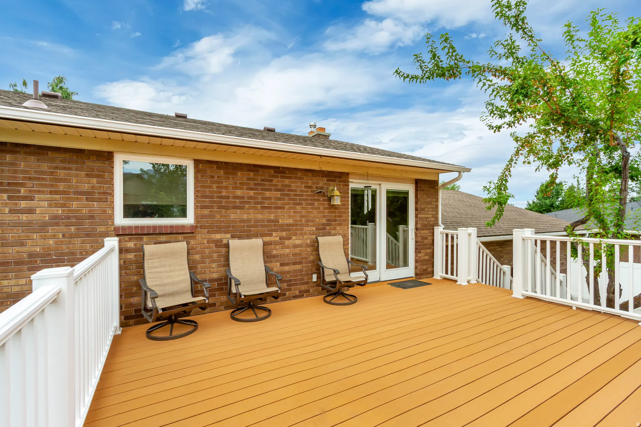 Expansive outdoor deck featuring wood-finish flooring and white perimeter railing