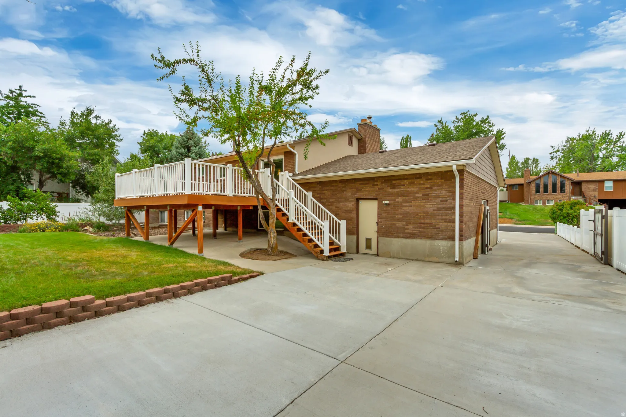 Elevated wood deck with white railings and staircase