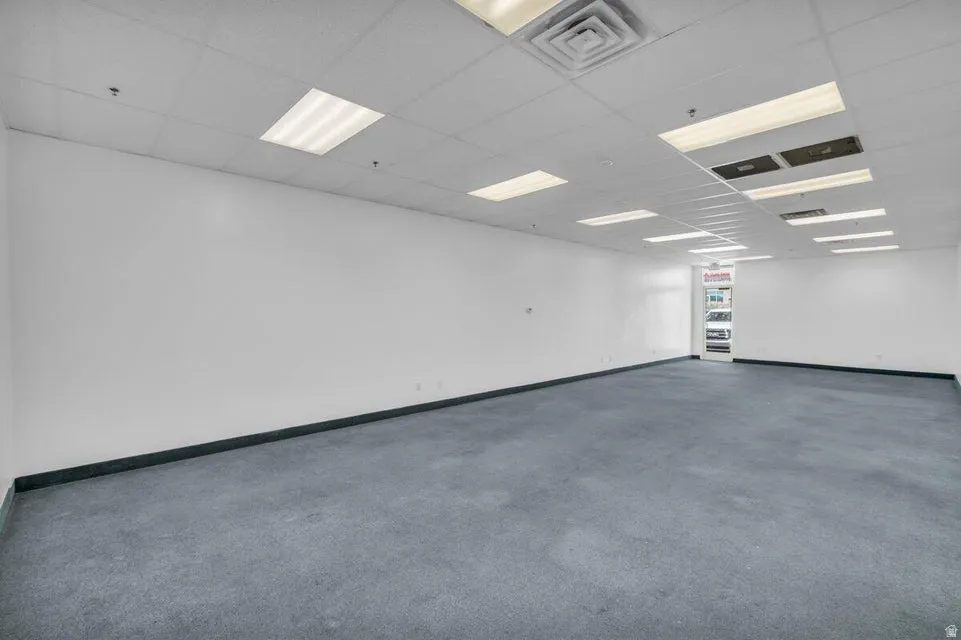 Spacious interior with neutral wall finishes and dark-toned carpeting