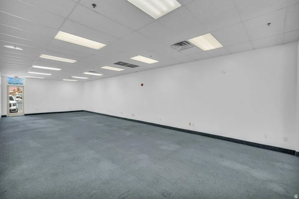 Spacious commercial interior featuring blue carpeting and white walls
