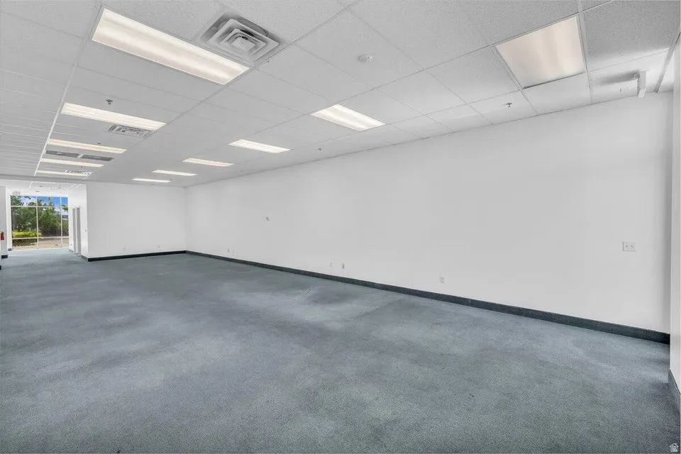 Expansive commercial interior with light blue carpet flooring and white painted walls