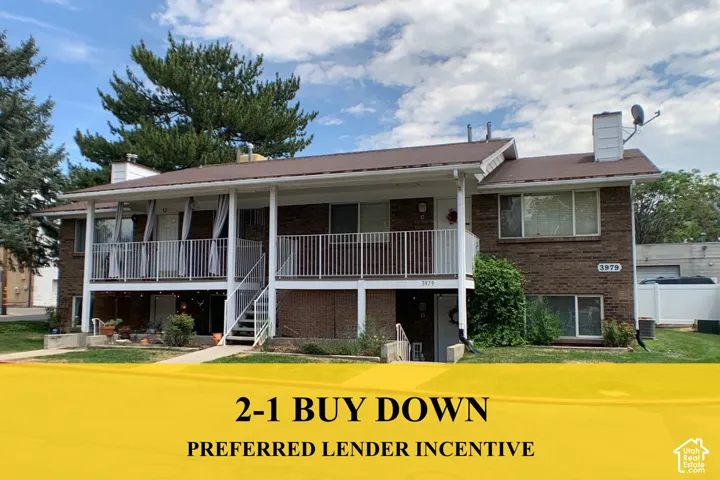 Multi-level brick exterior featuring a covered upper-level balcony with white metal railings, a shingle roof, and exterior stair access