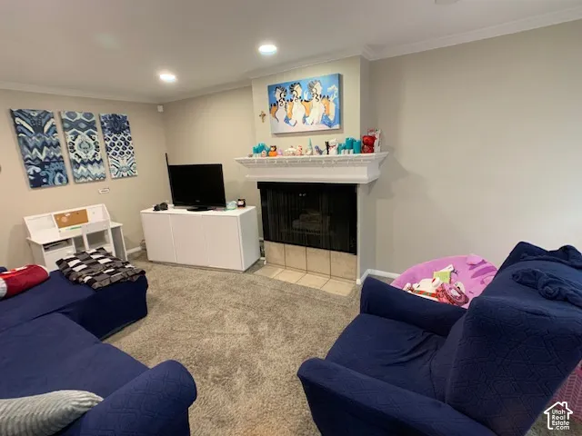 Fireplace featuring a white decorative mantel, tile hearth, and inset metal screen, complemented by recessed lighting and crown molding