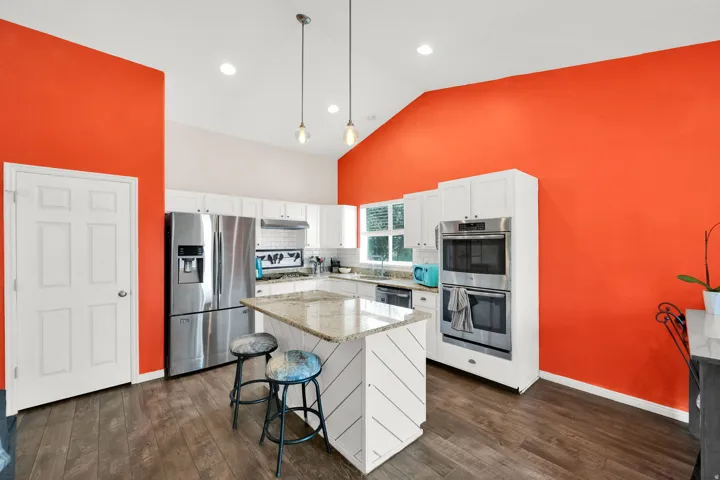 Modern kitchen featuring wood-finish flooring and a vaulted ceiling