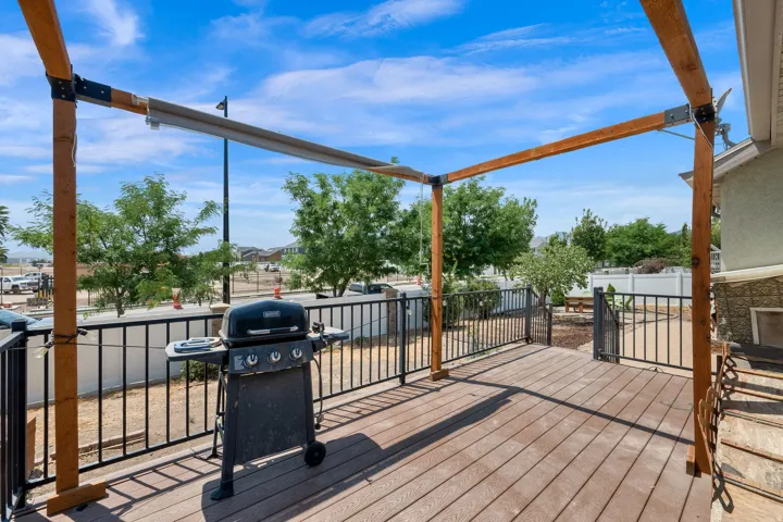 Expansive outdoor deck featuring wood-finish decking, a black metal railing, and a wooden pergola structure