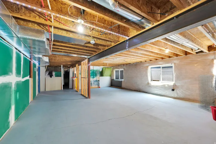 Spacious unfinished basement offering exposed wood joists, ductwork, and an exposed steel I-beam