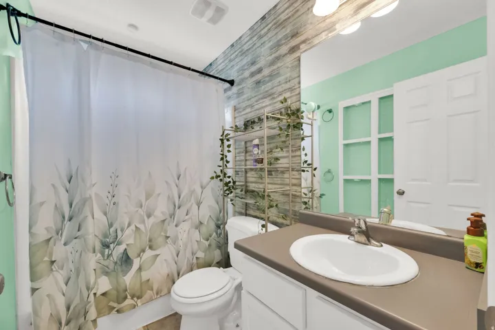 Bathroom featuring a single vanity with a white basin and a brown countertop