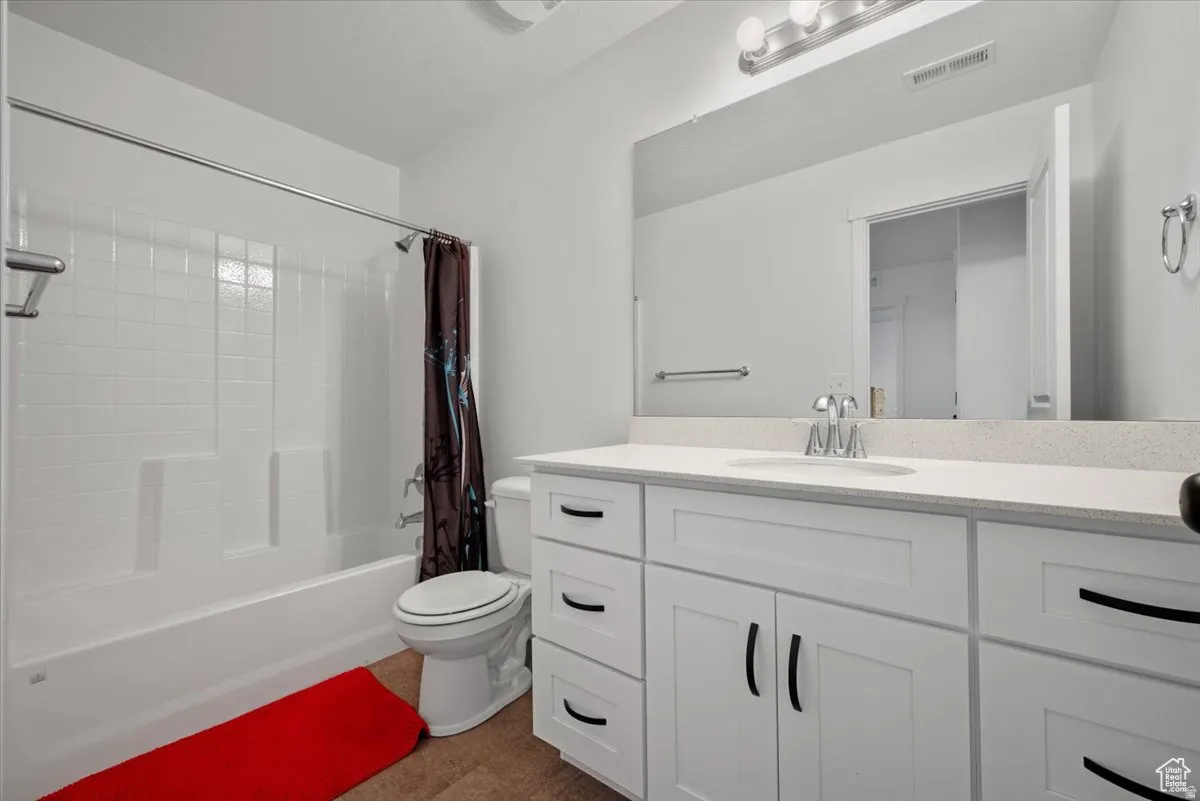 Bathroom featuring a white vanity with extensive counter space and white cabinetry
