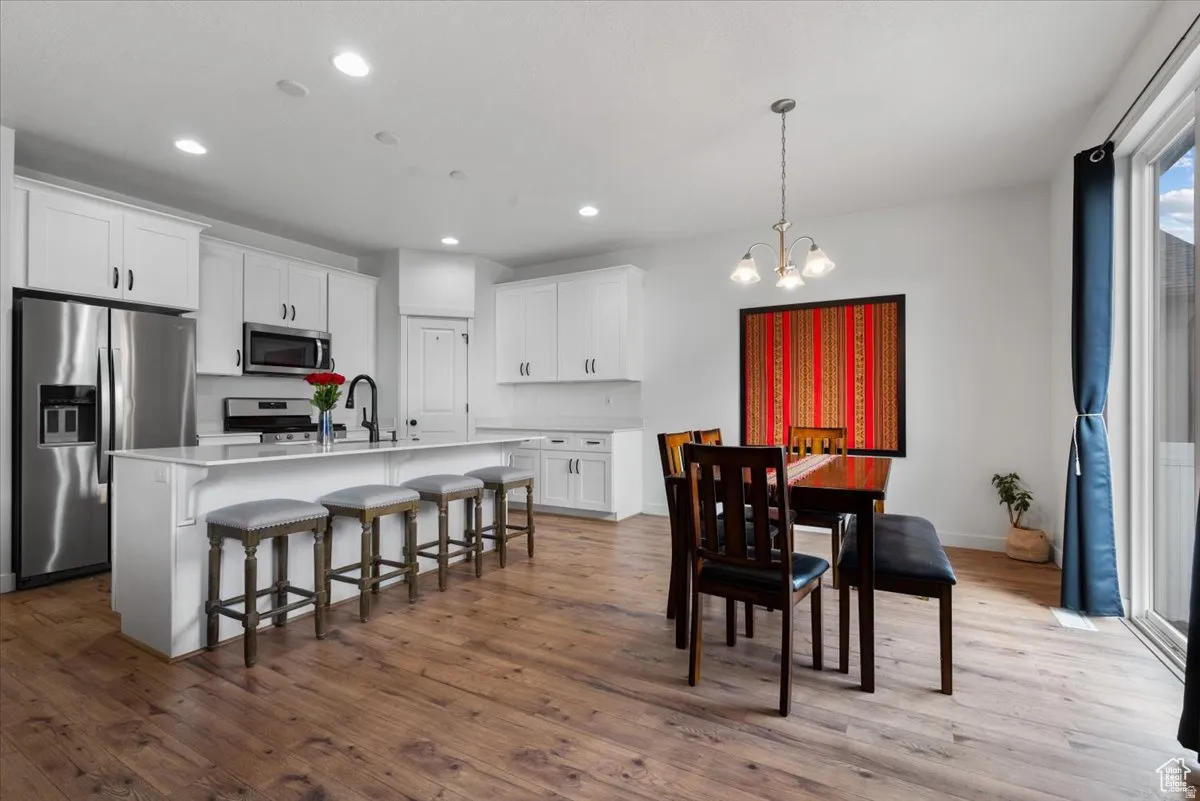 Open-concept kitchen and dining area featuring wood-finish flooring