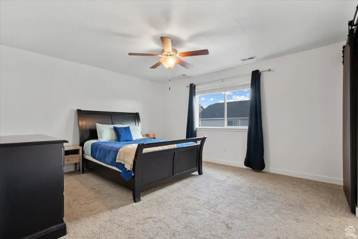 Carpeted room featuring a ceiling fan with integrated lighting, a window with blinds, and white painted walls