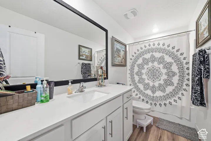 Bathroom vanity with a single basin sink, white countertop, and white cabinetry