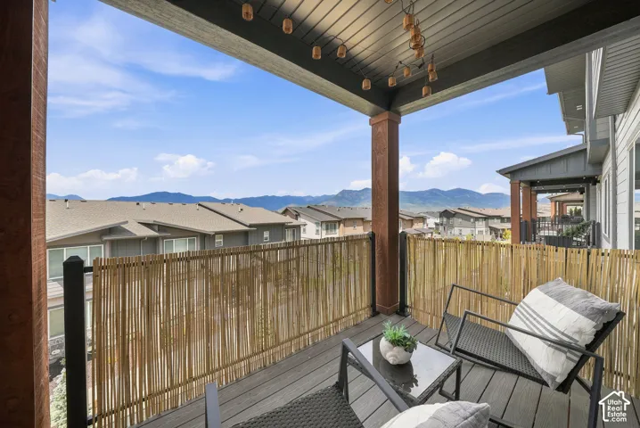 Covered outdoor deck with composite decking, a bamboo-style screen, and mountain scenery