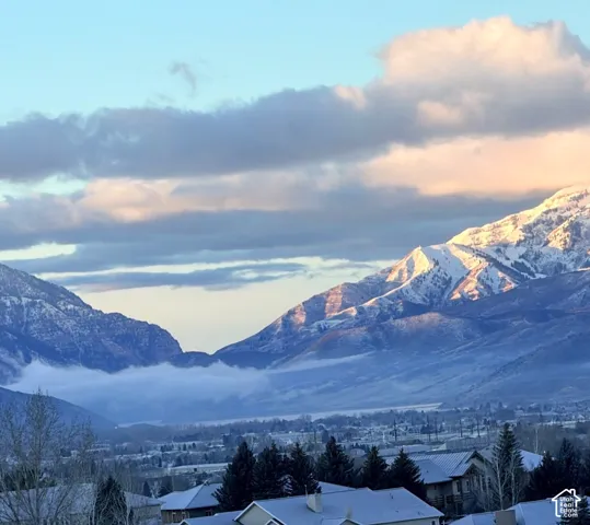 Snow-capped mountain range encompassing a valley with residential structures