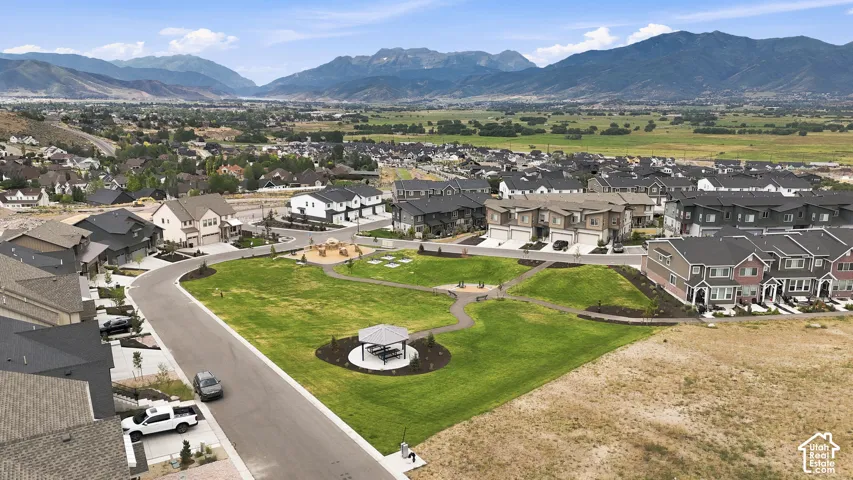 Community green space featuring a paved walking path, gazebo, and playground area