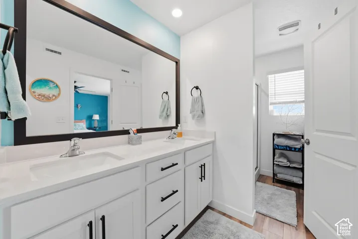 Dual vanity with white cabinetry and black hardware, set under a large framed mirror