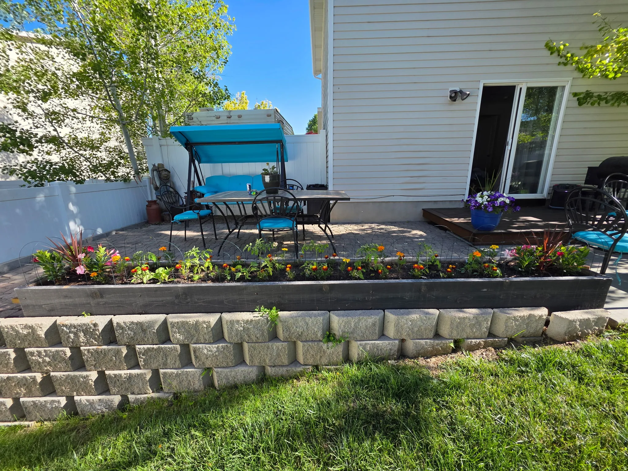 Tiered retaining wall with a stone block base, topped by a wood-finish planter box