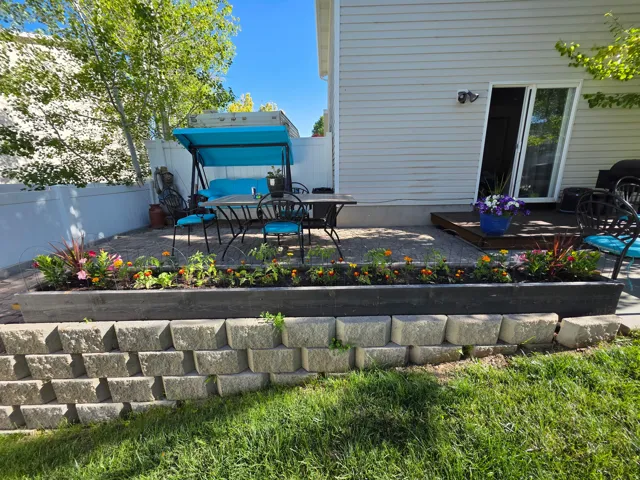 Tiered retaining wall with a stone block base, topped by a wood-finish planter box