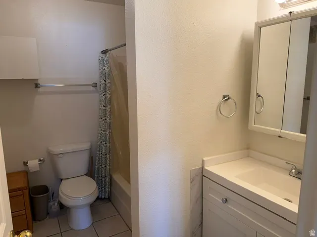 Full bathroom featuring a white vanity with integrated sink, a mirrored medicine cabinet, a toilet, and a shower-tub combination