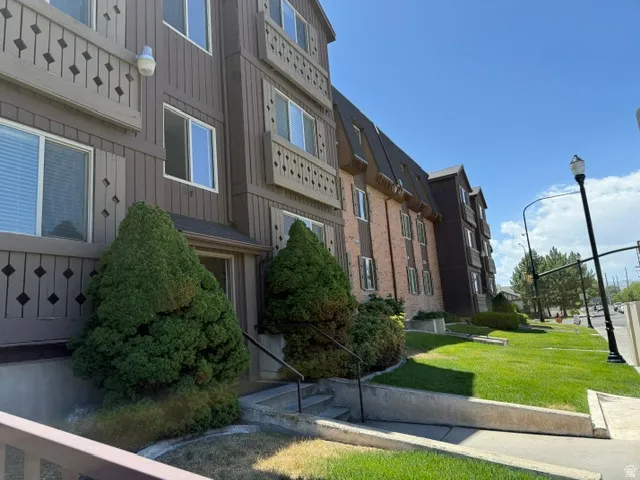 Multi-story building exterior featuring brown siding and brick accents