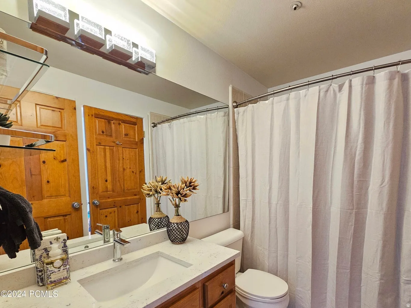 Bathroom vanity with a rectangular undermount sink, a chrome faucet, and a light-toned countertop