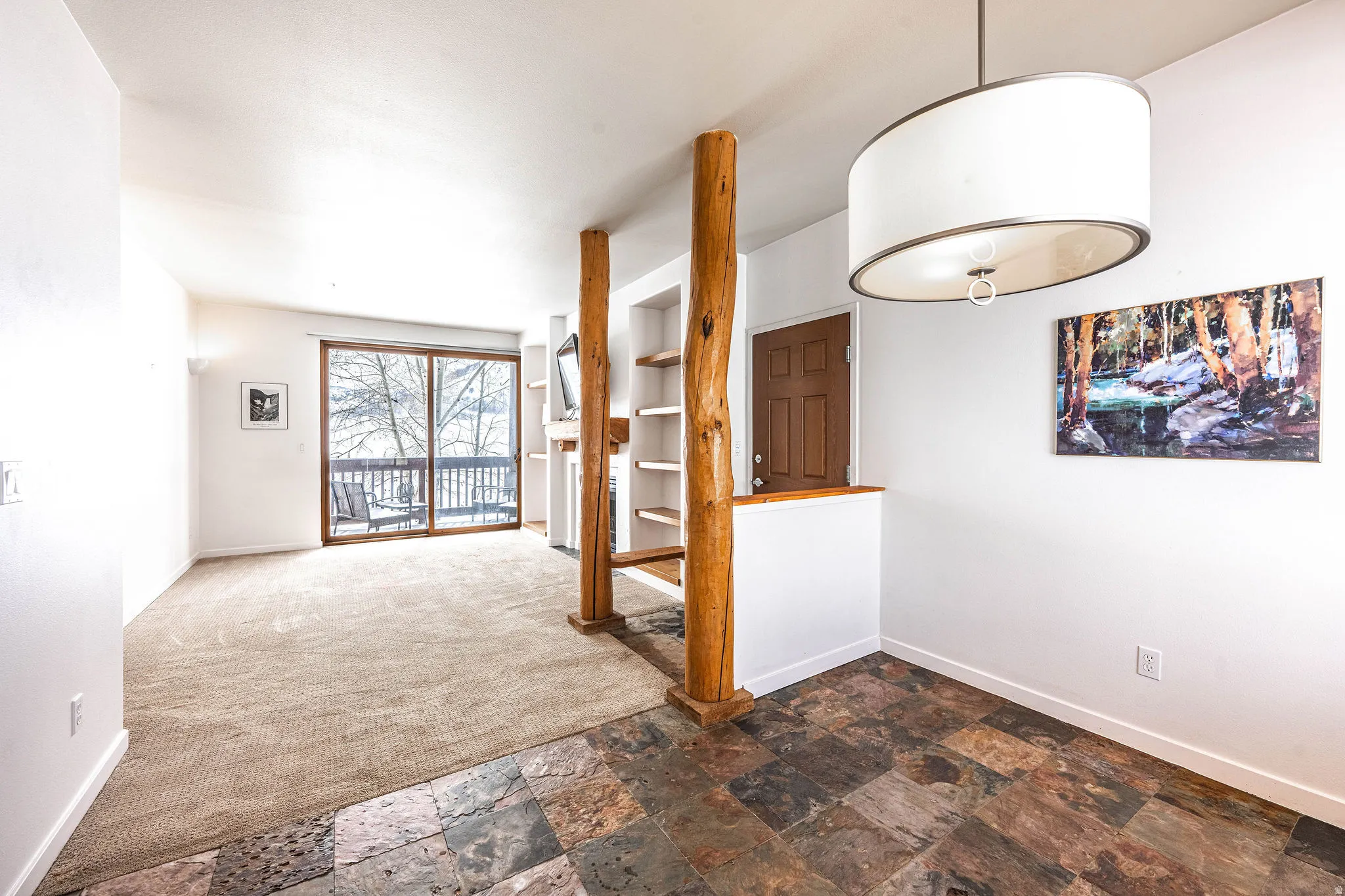 Interior space featuring varied flooring, a fireplace, and built-in shelving