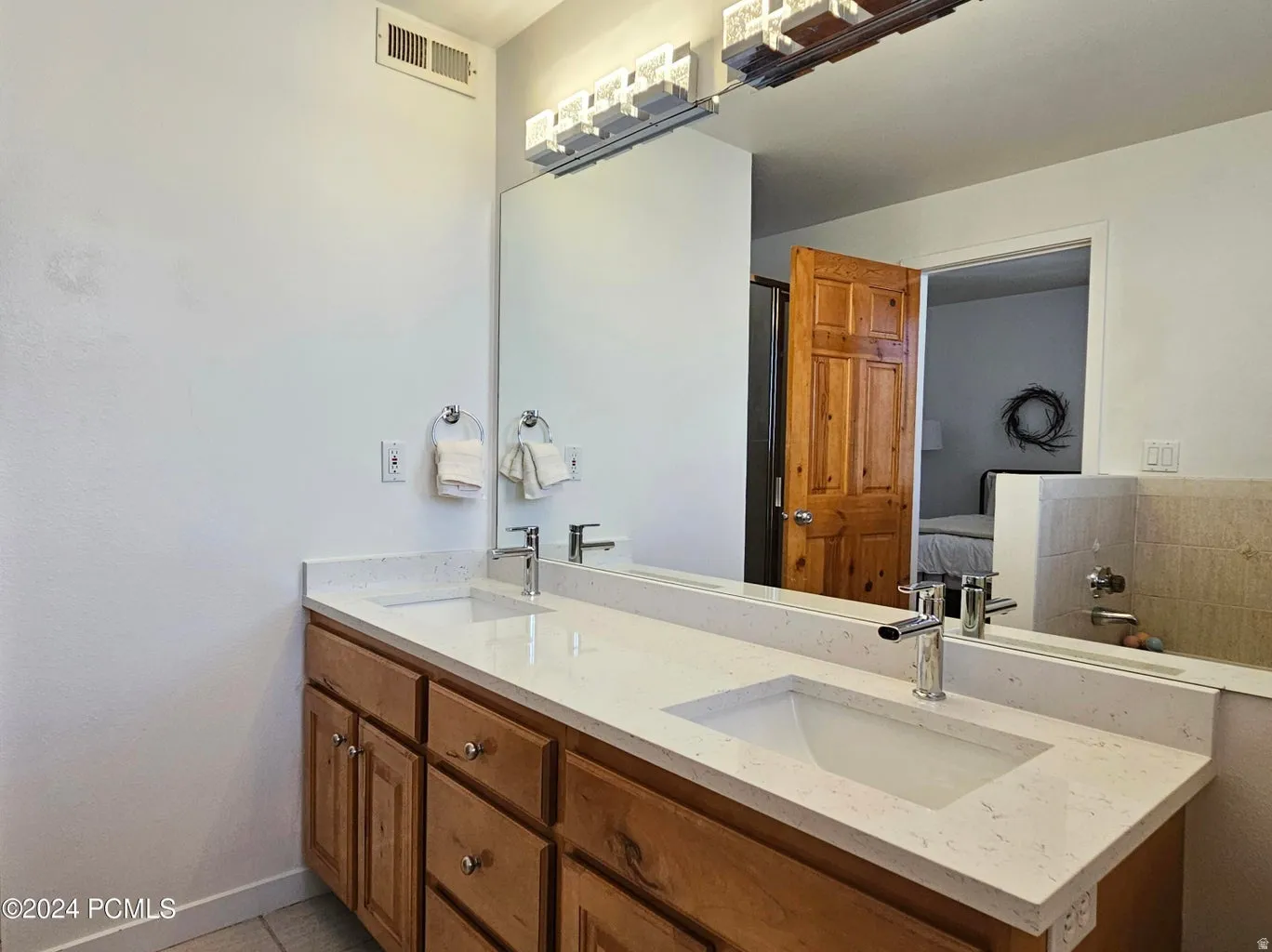 Double vanity with light-toned countertop, dual rectangular sinks, and chrome faucets