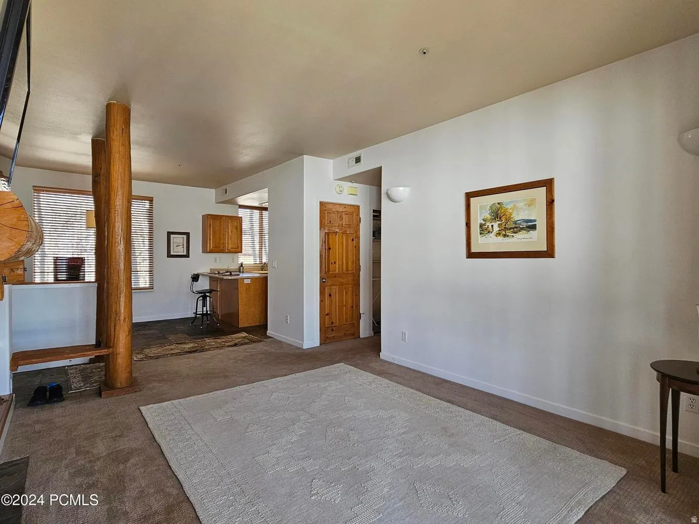 Spacious living area featuring neutral carpeting and white wall finishes