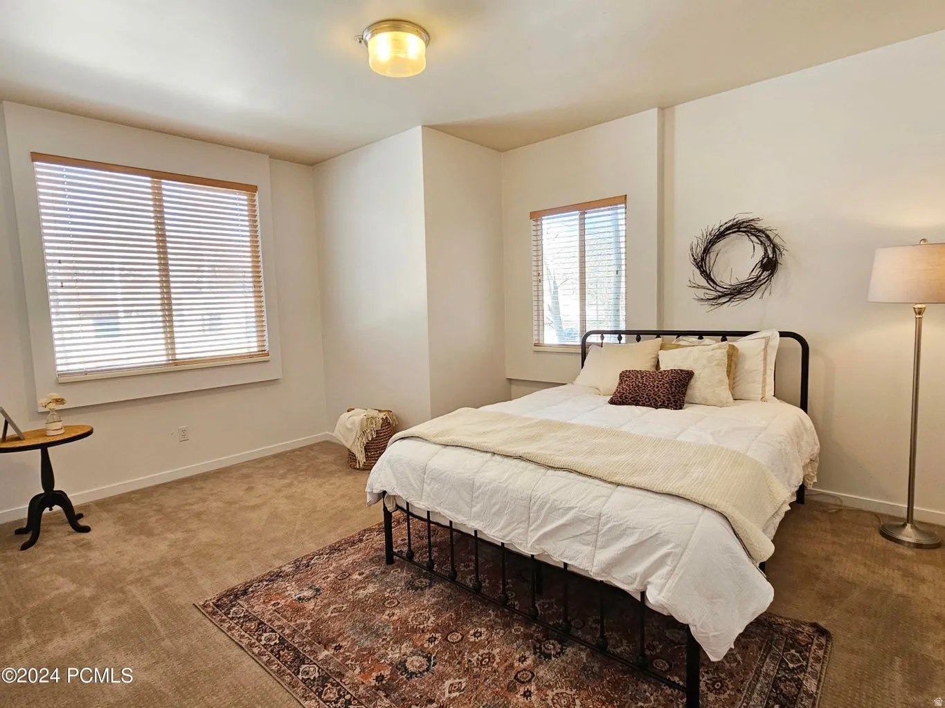 Carpeted room with two windows featuring wooden blinds