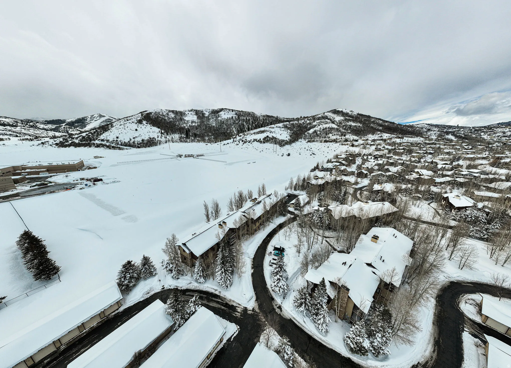 Aerial perspective showcasing multiple residential structures amidst a snow-covered landscape