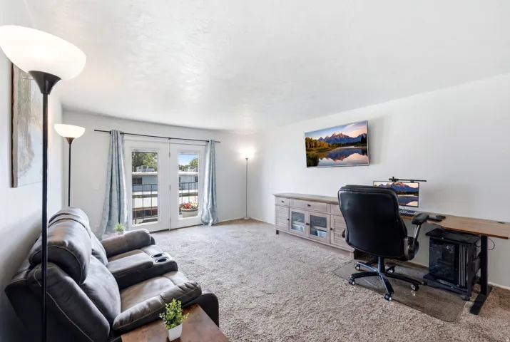 Living area featuring a textured ceiling, neutral carpeting, and white walls