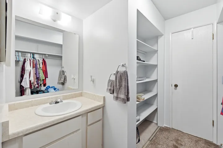 Bathroom vanity featuring a single basin sink, laminate countertop, and built-in cabinetry
