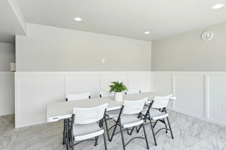 Clean, bright room featuring recessed lighting, white paneling, light gray walls, and large format marble-patterned floor tiles