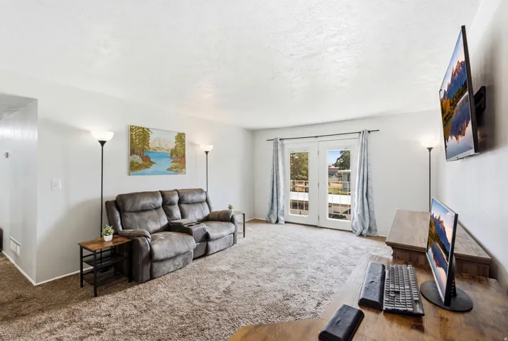 Carpeted living area featuring white walls and white trim