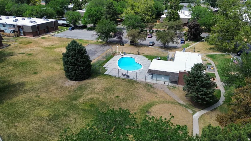 Outdoor swimming pool with surrounding concrete patio and perimeter fencing
