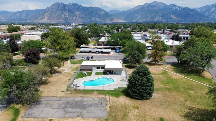 Community swimming pool with surrounding green spaces and mountain backdrop