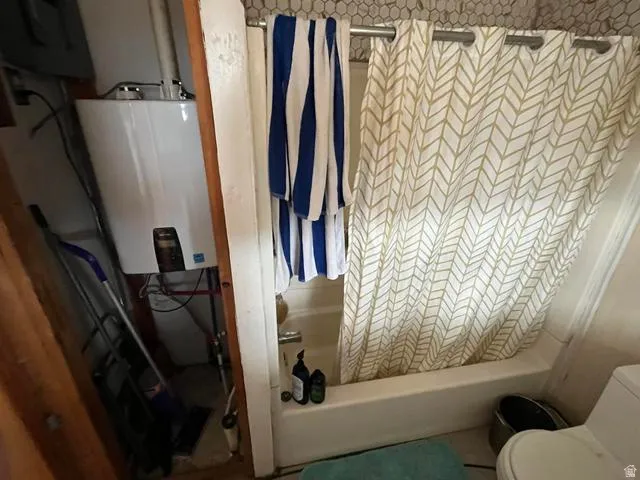 White bathtub with a patterned shower curtain and white subway tile surround
