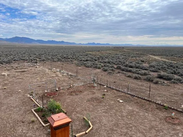 Expansive desert landscape featuring distant mountains and a cloudy sky
