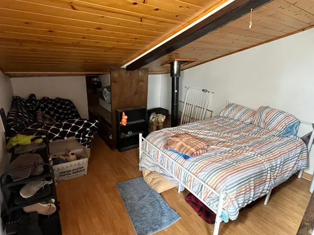 Wood-finish flooring, wood-paneled ceiling, and exposed structural beam
