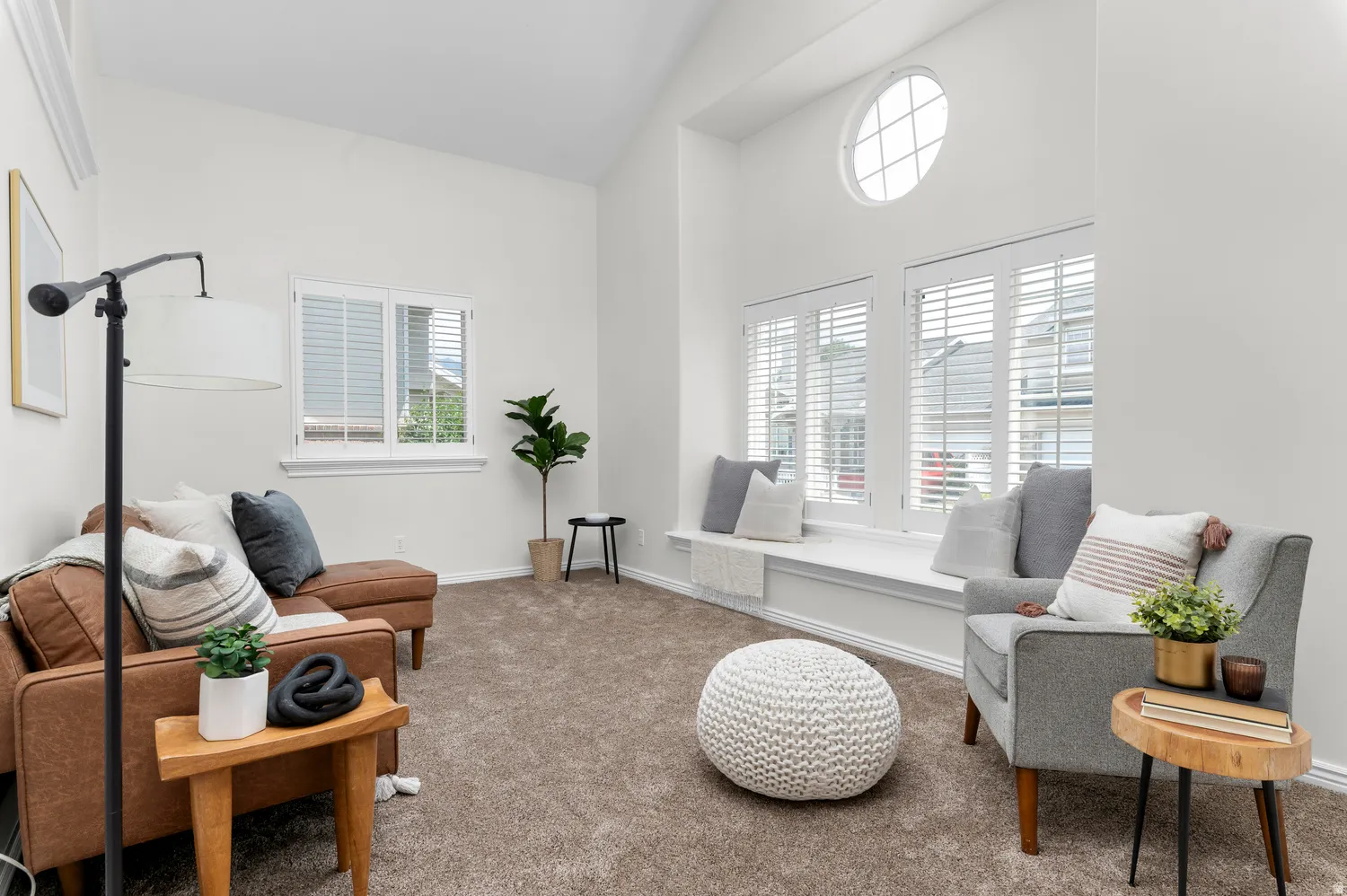 Living area featuring a vaulted ceiling and an arched window