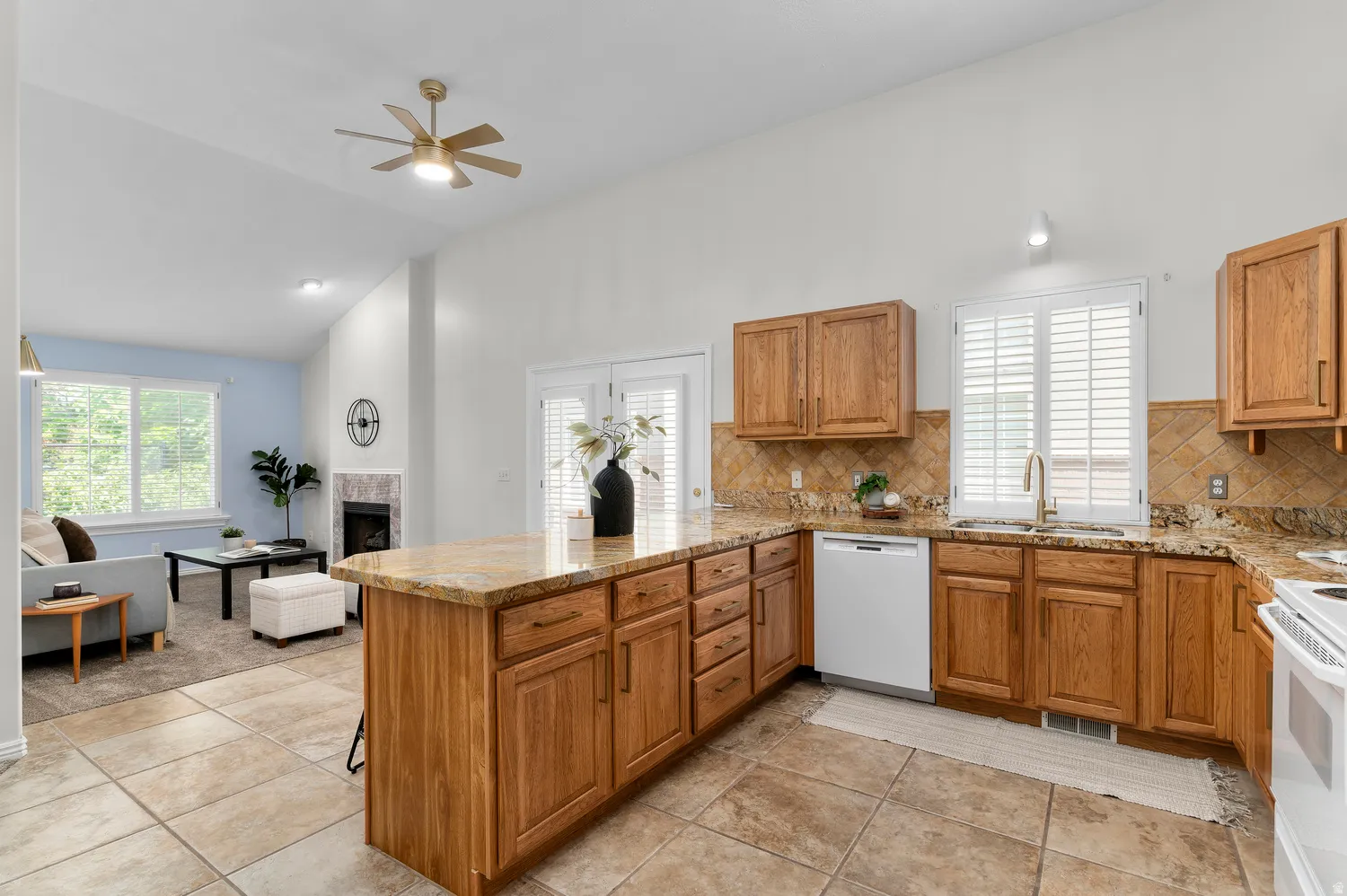 Kitchen with wood-finish cabinetry, stone countertops, and tile backsplash, featuring a kitchen island and stainless steel appliances