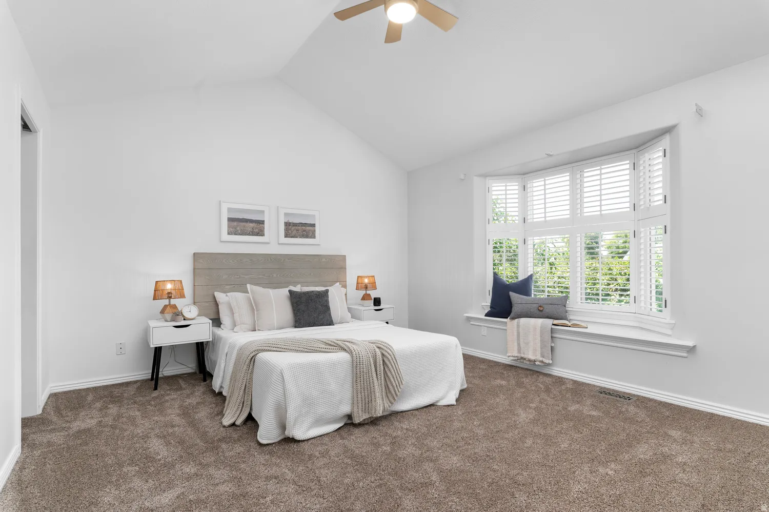 Primary Bedroom featuring a vaulted ceiling and a bay window with plantation shutters