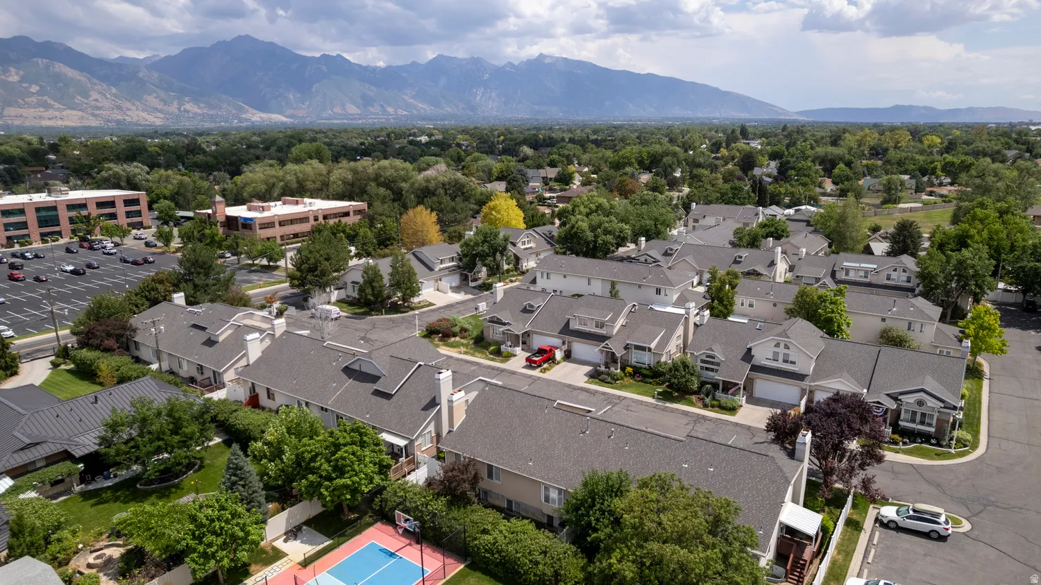 Aerial perspective of a residential community featuring multiple dwellings with gray shingle roofs
