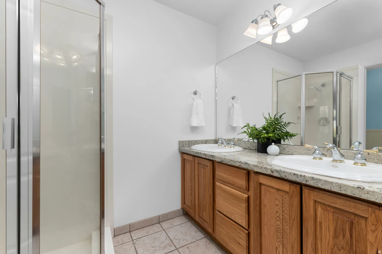 Primary Bathroom featuring a double vanity with granite countertop