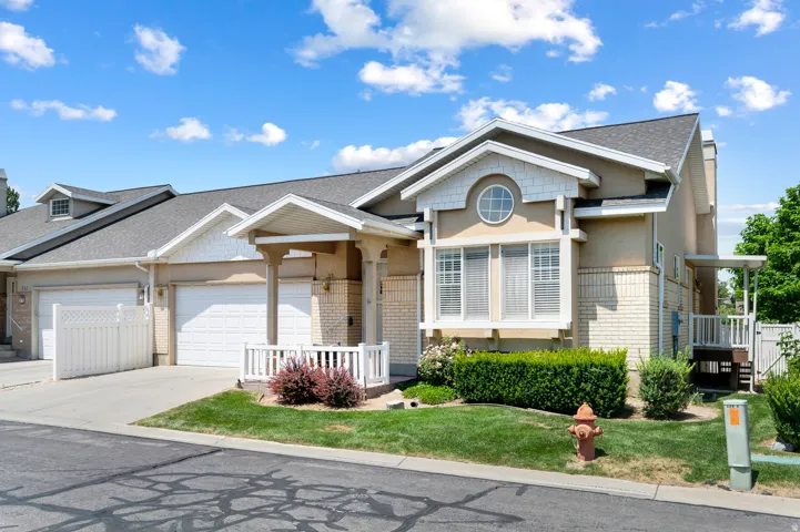 Multi-level exterior featuring stucco and brick accents, a gabled roofline, and a prominent bay window with an upper circular window detail