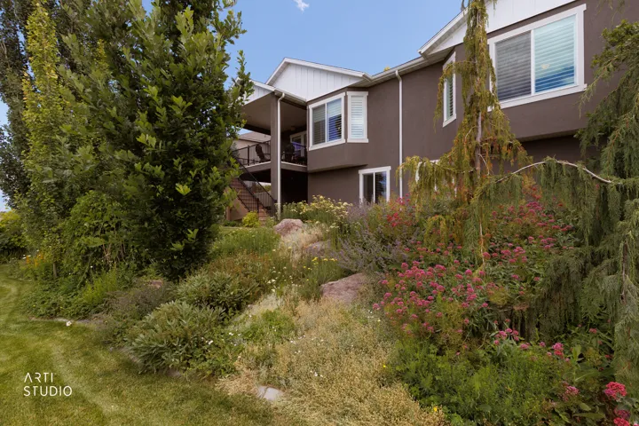 Terraced landscaping featuring mature trees, diverse plantings, and flowering shrubs