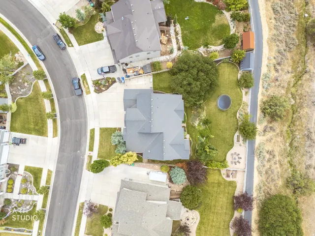 Expansive property featuring a curved driveway, established landscaping, a spacious backyard, and a dedicated fire pit area