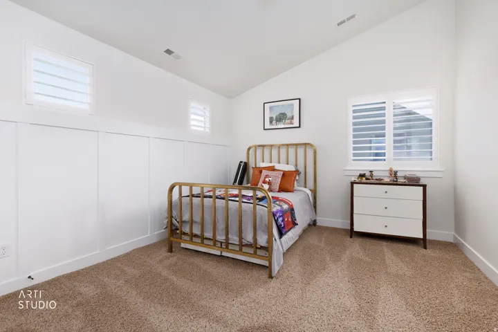 Bright interior space featuring a vaulted ceiling and textured carpeting
