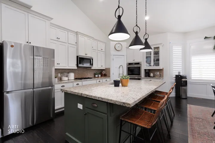 Kitchen featuring a spacious island with granite countertops, stainless steel appliances, white cabinetry, dark wood-finish flooring, and vaulted ceilings